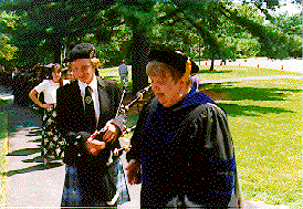 Pat and Bagpiper leading graduating students.width=